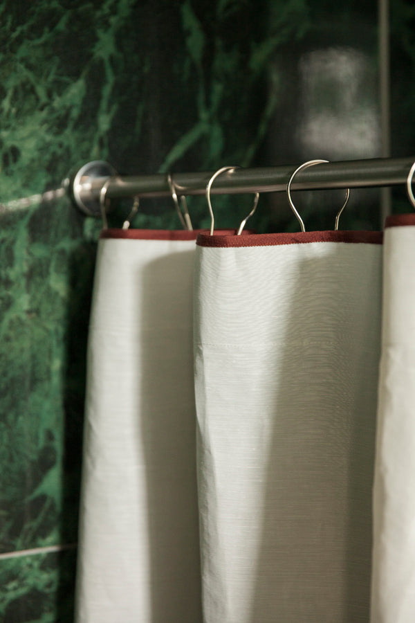 Winther Wackerhausen Clean shower curtain featuring Deep Reddish Brown trim, styled in a bathroom with deep green marble tiles and stainless steel shower rod