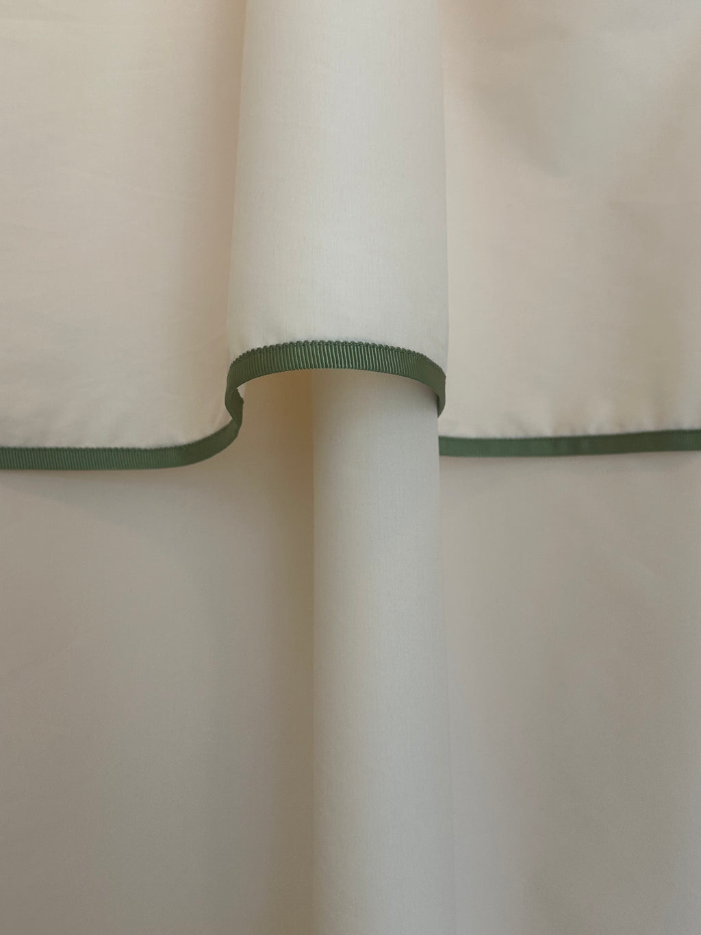 Detailed close-up of the Winther Wackerhausen Contour shower curtain showing the sculpted top fold and refined green trim