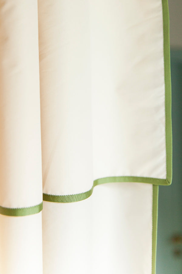 Contour shower curtain in cream with a soft green wave trim, adding a clean and modern touch to any bathroom.