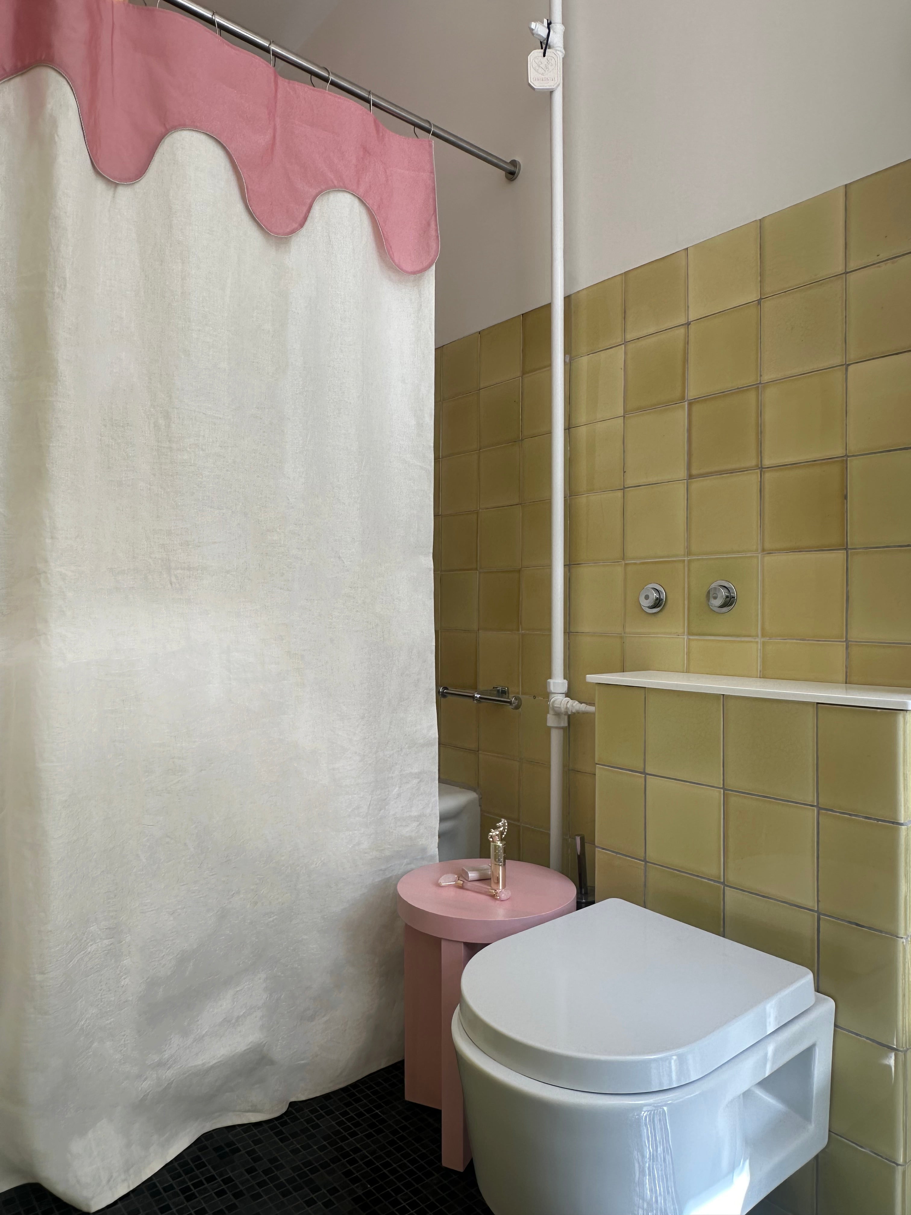 Hero image featuring the Drizzle shower curtain by Winther Wackerhausen, with its signature pink scalloped top and white linen blend body, styled in a vintage-inspired bathroom