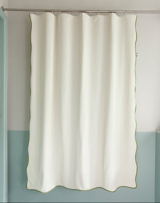Packshot of the Wave shower curtain by Winther Wackerhausen, featuring its signature flowing wavy hem and subtle green trim in a minimalist bathroom setting